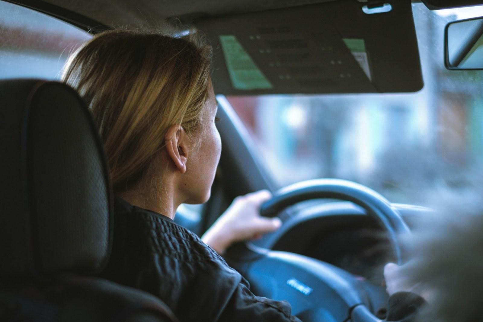 A young woman driving, focused and confident behind the wheel